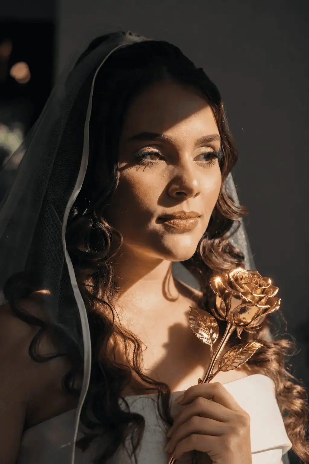 Portrait of a bride holding a single gold dipped rose close to her face, a eternal gold rose gift idea for Cannes, France