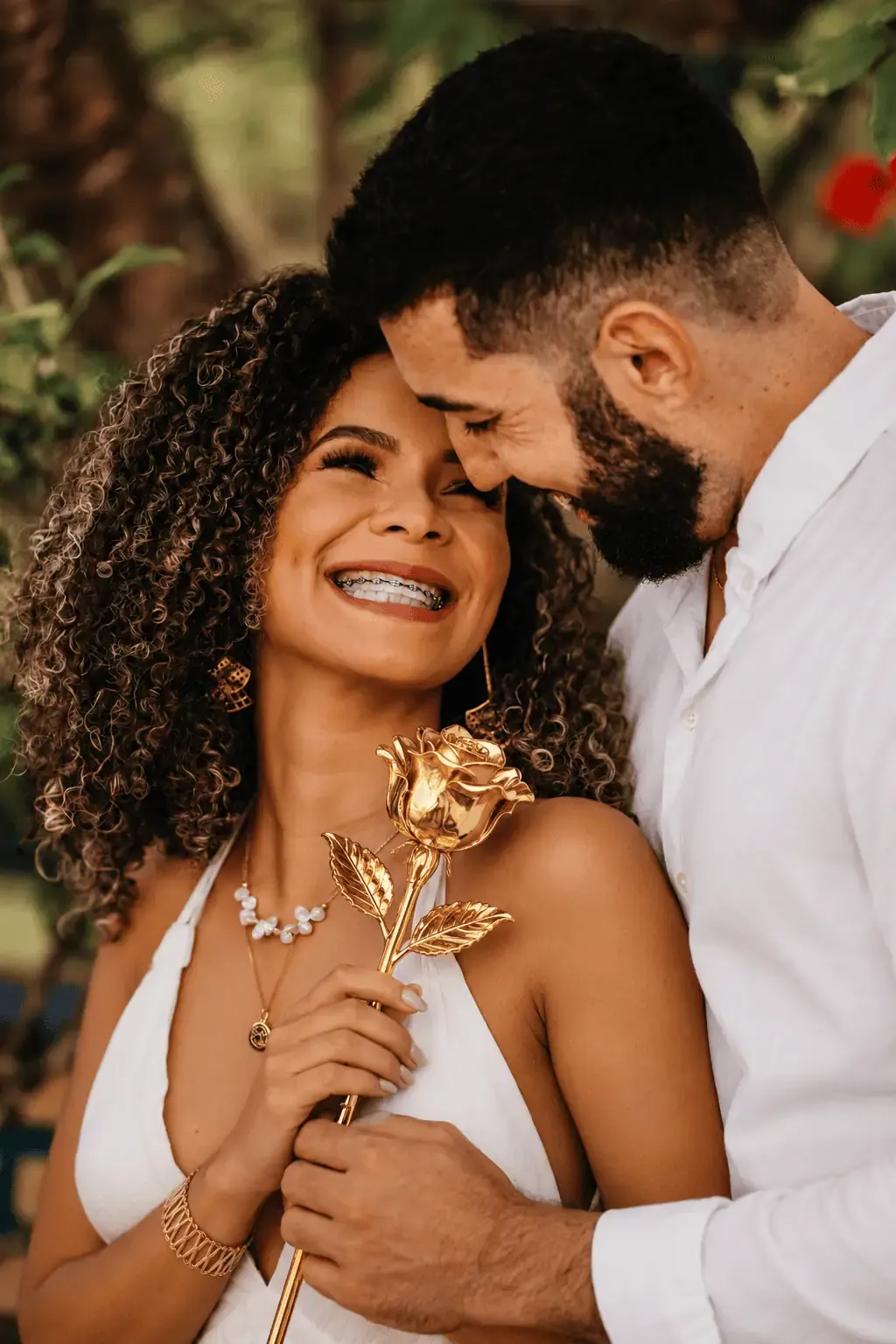 Couple embracing while she holds a 24K gold dipped rose, a gold rose delivery gift idea for New York, United States