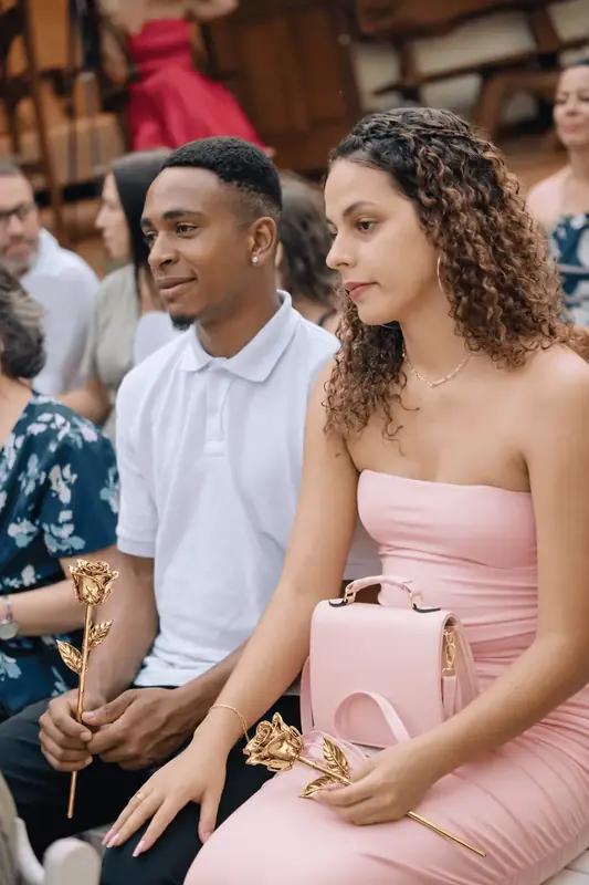 Young couple of wedding guests holding a gold dipped rose, woman in a pink dress, questions about choosing a gold dipped rose gift